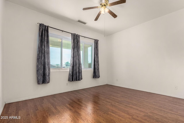 empty room with visible vents, wood finished floors, and a ceiling fan