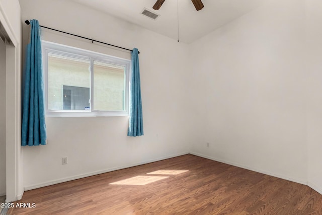 unfurnished room featuring a ceiling fan, wood finished floors, and visible vents