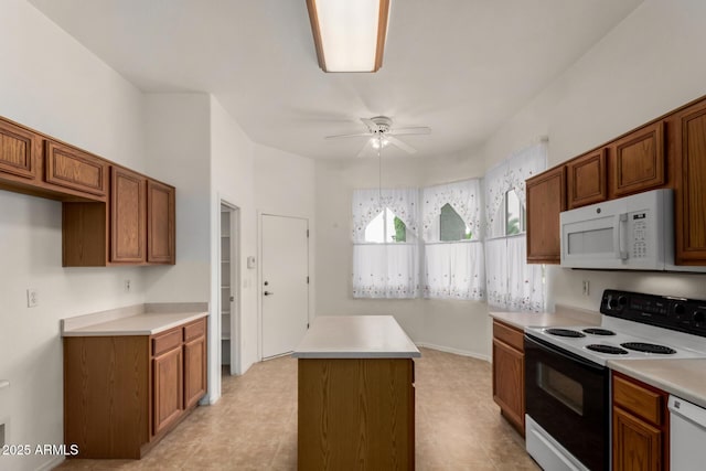 kitchen featuring a center island, white appliances, brown cabinets, and a ceiling fan