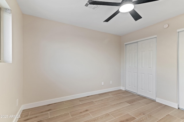 unfurnished bedroom with ceiling fan and a closet