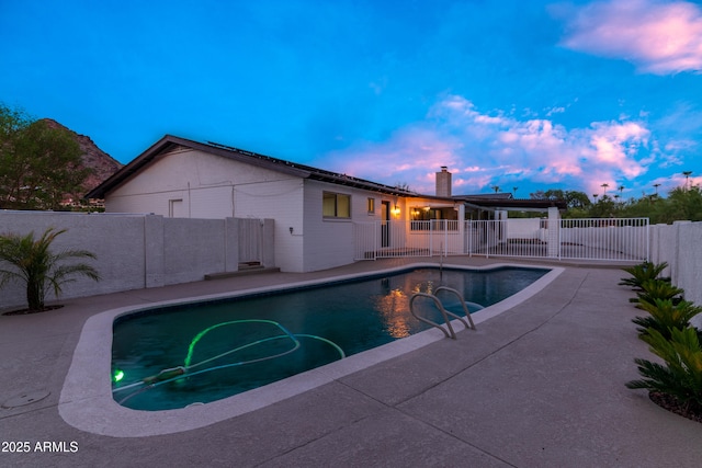 pool at dusk with a patio