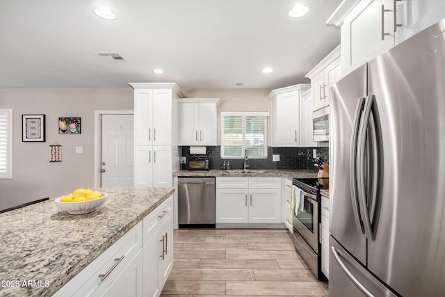508 S Ernie Pl, Tempe, AZ 85281 - kitchen featuring backsplash, visible vents, appliances with stainless steel finishes, a sink, and white cabinetry