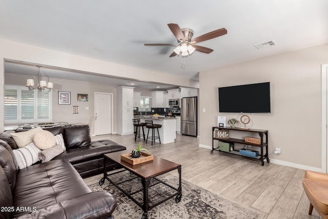 508 S Ernie Pl, Tempe, AZ 85281 - living area with visible vents, baseboards, ceiling fan with notable chandelier, and light wood-type flooring