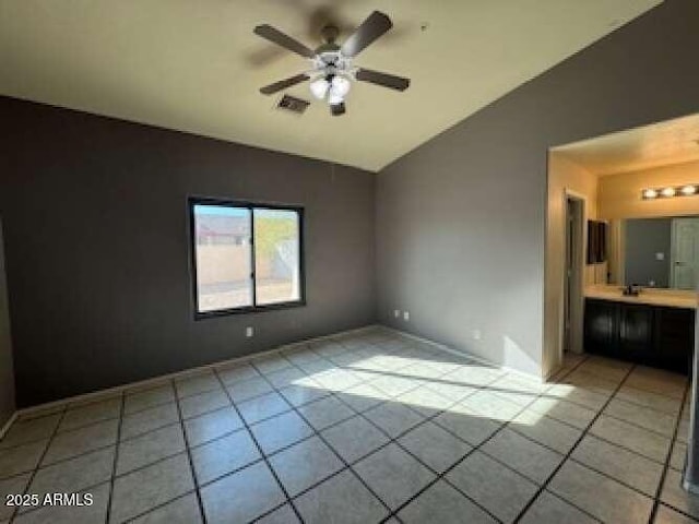 empty room featuring visible vents, vaulted ceiling, a ceiling fan, and light tile patterned flooring