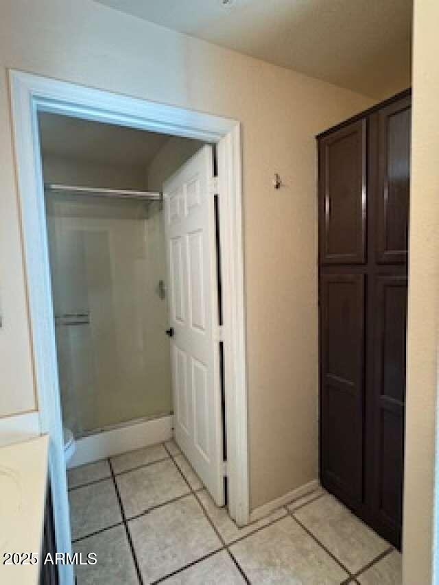 full bath featuring a stall shower, baseboards, and vanity