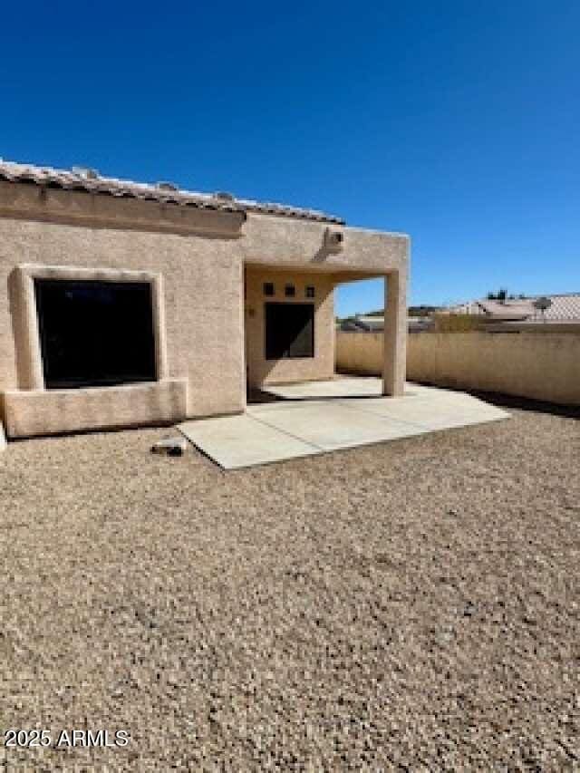 back of house with a patio area, fence, and stucco siding