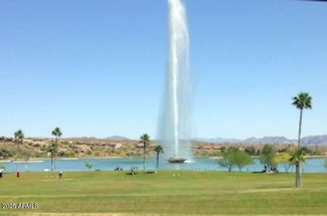 view of community with a yard and a water view