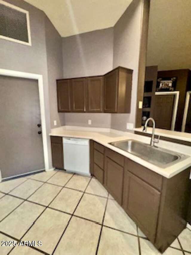 kitchen featuring a sink, light countertops, dishwasher, and light tile patterned flooring