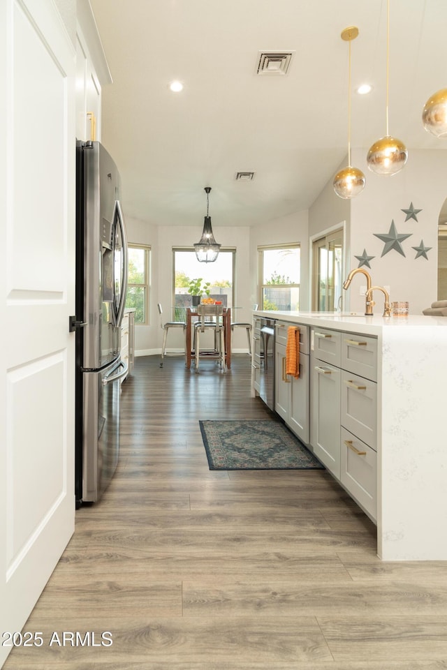 136 E Vera Ln, Tempe, AZ 85284 - kitchen featuring stainless steel refrigerator with ice dispenser, recessed lighting, light wood-style floors, hanging light fixtures, and white cabinets