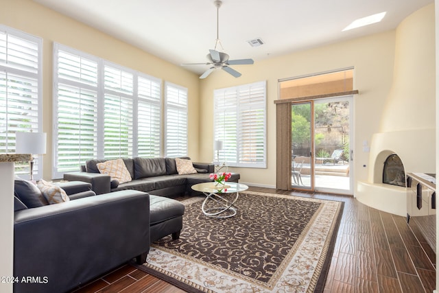 living room featuring a wealth of natural light, dark wood-type flooring, and ceiling fan