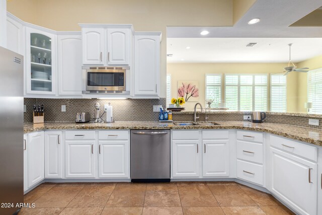 kitchen with white cabinets, appliances with stainless steel finishes, ceiling fan, and sink