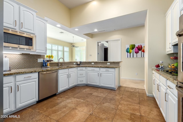 kitchen with ceiling fan, white cabinets, dark stone counters, and appliances with stainless steel finishes