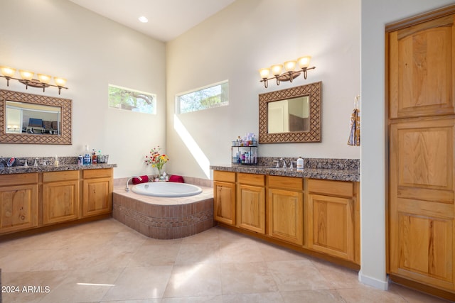 bathroom with vanity, tile patterned floors, and tiled tub