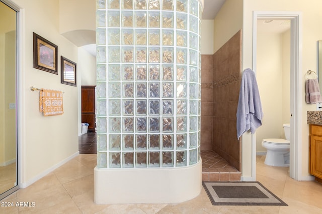 bathroom with tile patterned floors, vanity, toilet, and tiled shower