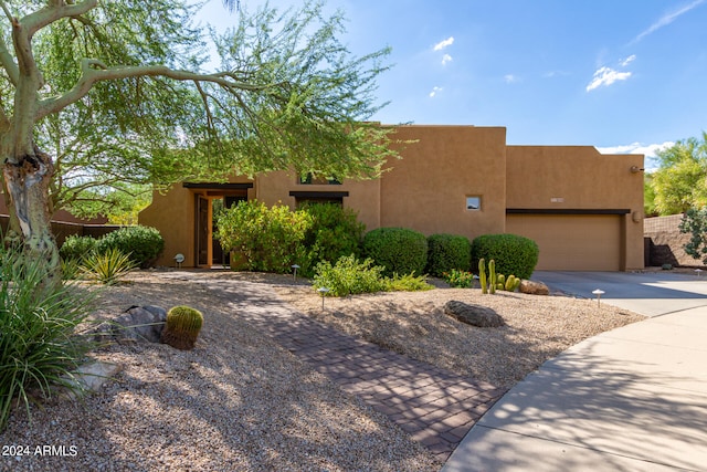 pueblo revival-style home with a garage