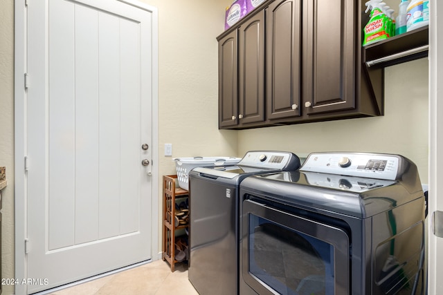 washroom with light tile patterned flooring, cabinets, and independent washer and dryer