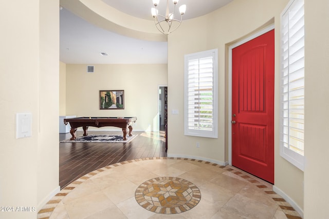 entrance foyer with a notable chandelier, pool table, and light hardwood / wood-style flooring