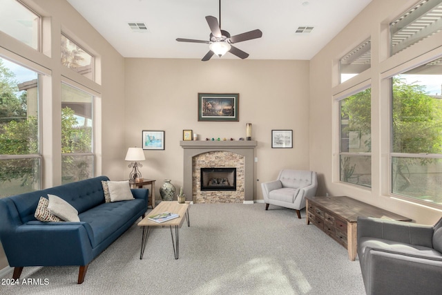 living room featuring carpet flooring, ceiling fan, and a fireplace