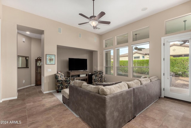 living room with ceiling fan and a fireplace