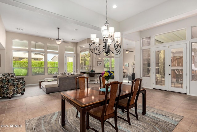 tiled dining space featuring french doors, ceiling fan with notable chandelier, and a healthy amount of sunlight