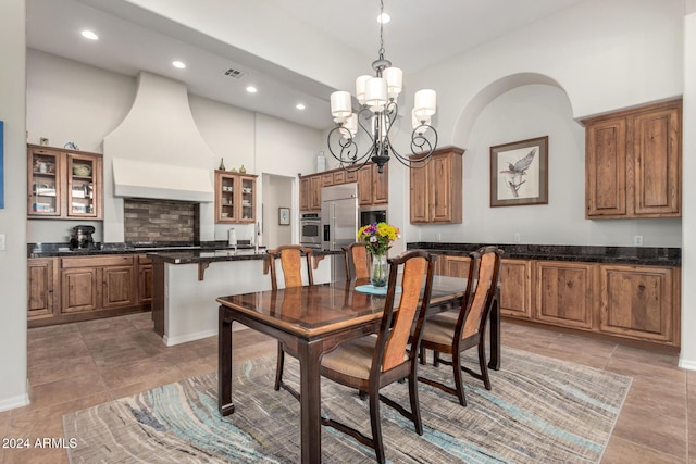 dining room with a high ceiling and a notable chandelier