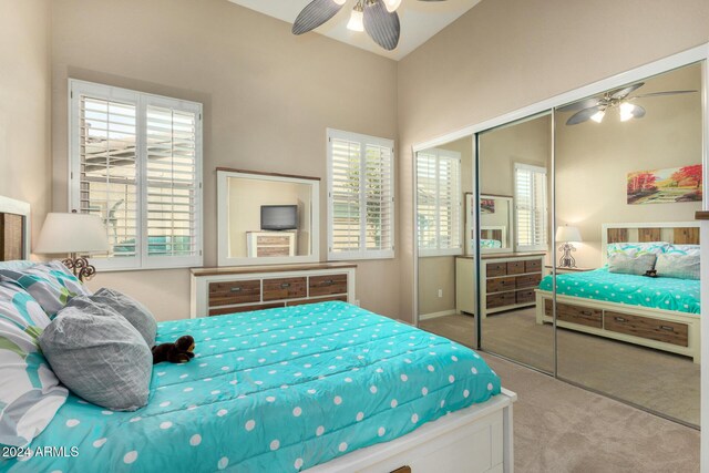 bedroom featuring carpet, ceiling fan, vaulted ceiling, and a closet