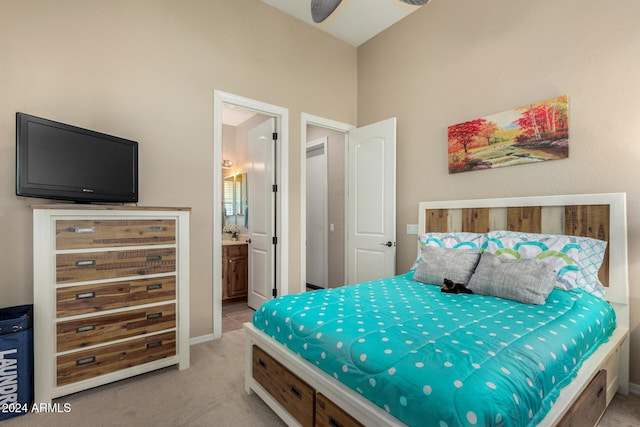 bedroom featuring ensuite bath, light carpet, and ceiling fan