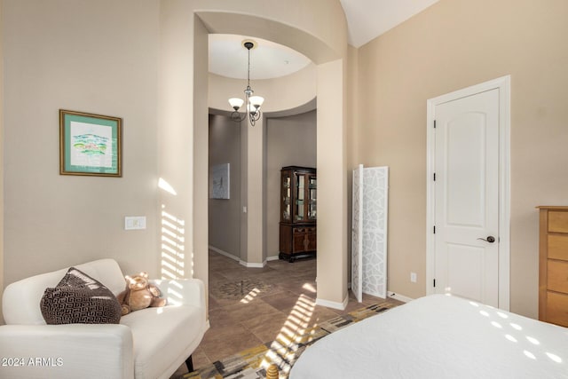 bedroom featuring a high ceiling and a notable chandelier