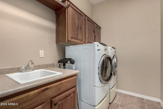 washroom featuring washing machine and clothes dryer, sink, and cabinets