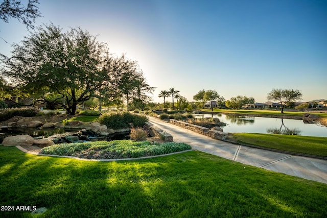 view of home's community with a lawn and a water view