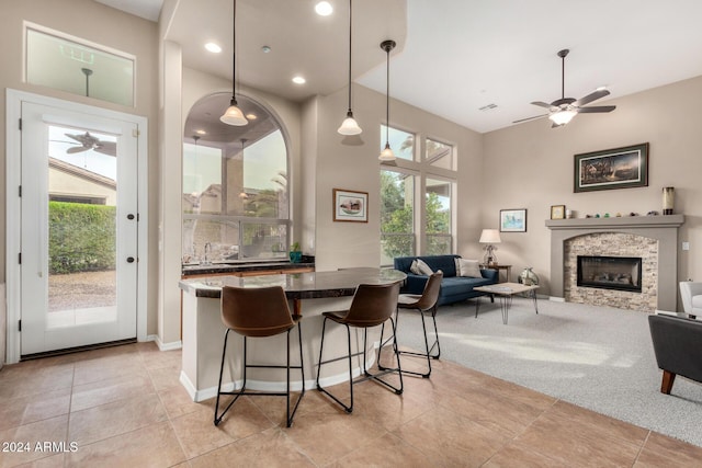 kitchen featuring pendant lighting, plenty of natural light, a kitchen bar, and a fireplace