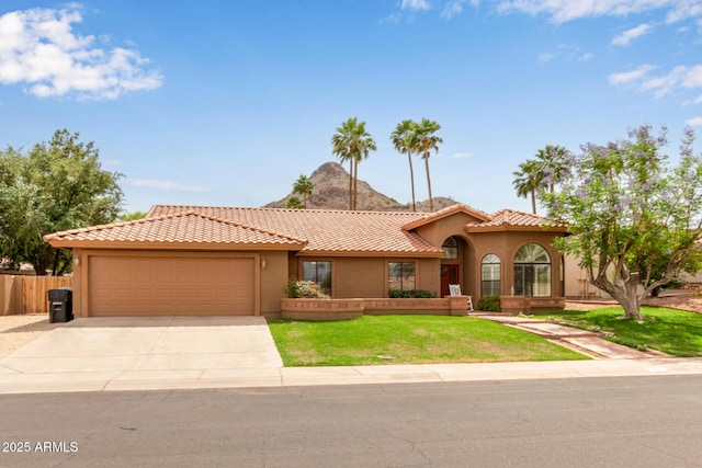 15430 N 19th Way, Phoenix, AZ 85022 - mediterranean / spanish home featuring an attached garage, concrete driveway, stucco siding, and a tiled roof
