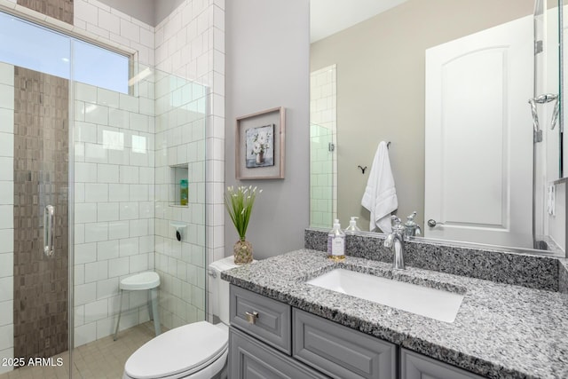 full bathroom with toilet, vanity, and tiled shower