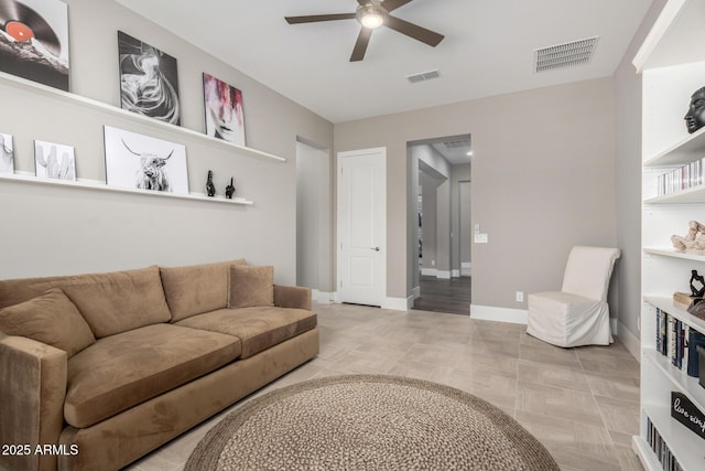 living room featuring baseboards, visible vents, and a ceiling fan