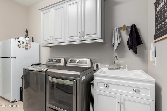 laundry area with separate washer and dryer and cabinet space
