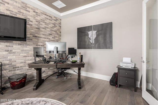 office space with baseboards, visible vents, and wood finished floors