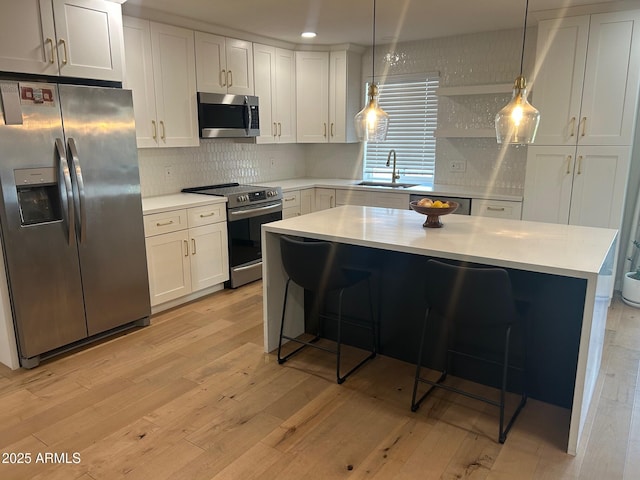 7802 E Hubbell St, Scottsdale, AZ 85257 - kitchen featuring appliances with stainless steel finishes, a sink, light wood-style floors, light countertops, and recessed lighting