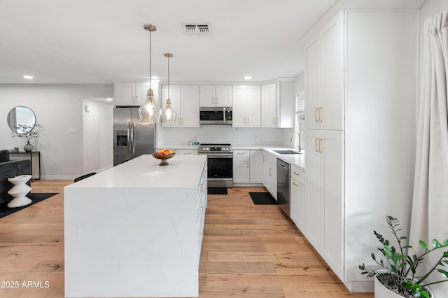 7802 E Hubbell St, Scottsdale, AZ 85257 - kitchen featuring appliances with stainless steel finishes, a sink, light wood-style floors, recessed lighting, and a center island