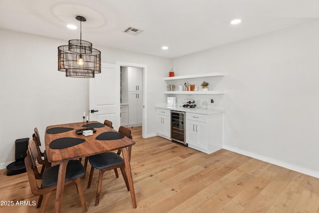 7802 E Hubbell St, Scottsdale, AZ 85257 - dining room featuring beverage cooler, a bar, light wood-style floors, recessed lighting, and baseboards