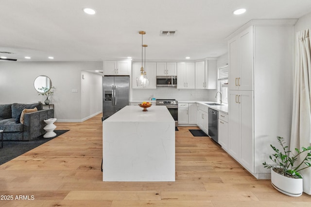 7802 E Hubbell St, Scottsdale, AZ 85257 - kitchen with stainless steel appliances, open floor plan, recessed lighting, a center island, and white cabinetry