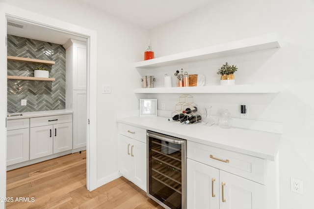 7802 E Hubbell St, Scottsdale, AZ 85257 - indoor dry bar with wine cooler, light wood finished floors, and decorative backsplash