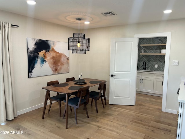 7802 E Hubbell St, Scottsdale, AZ 85257 - dining room with wet bar, light wood finished floors, baseboards, and recessed lighting
