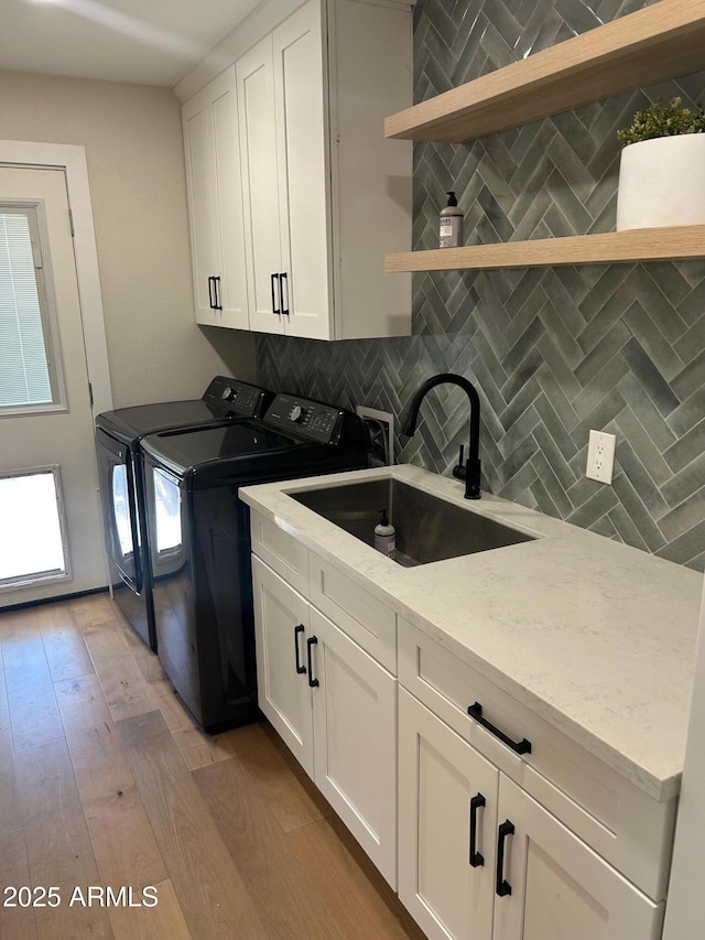 7802 E Hubbell St, Scottsdale, AZ 85257 - kitchen with a sink, washing machine and dryer, open shelves, decorative backsplash, and white cabinets