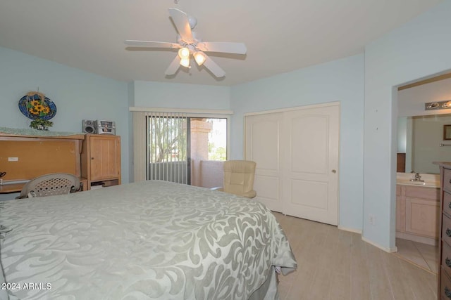 bedroom featuring a closet, light wood-type flooring, ensuite bath, sink, and ceiling fan