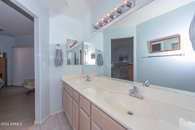 bathroom featuring dual sinks, vanity with extensive cabinet space, and hardwood / wood-style flooring