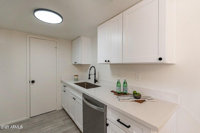 4268 N 68th Ave, Phoenix, AZ 85033 - kitchen with dishwasher, light countertops, light wood-type flooring, and white cabinets