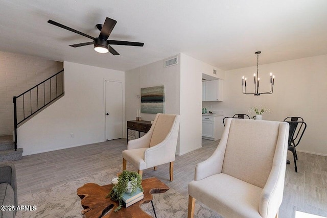 4268 N 68th Ave, Phoenix, AZ 85033 - living room with stairway, a chandelier, light wood-style floors, and ceiling fan