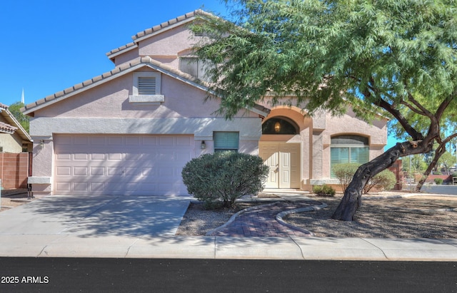 view of front of home featuring driveway, an attached garage, a tile roof, and stucco siding