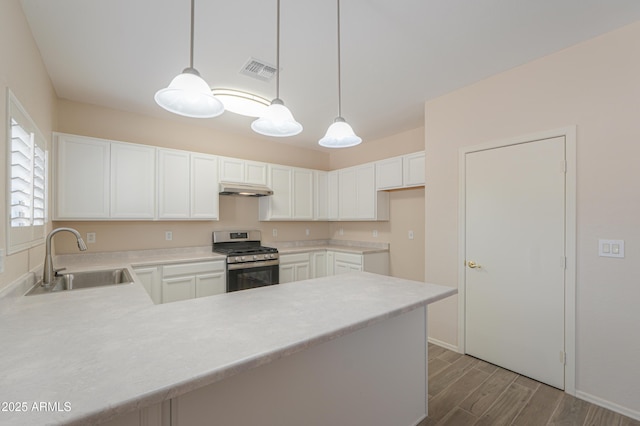 kitchen featuring a sink, visible vents, light countertops, stainless steel gas stove, and pendant lighting