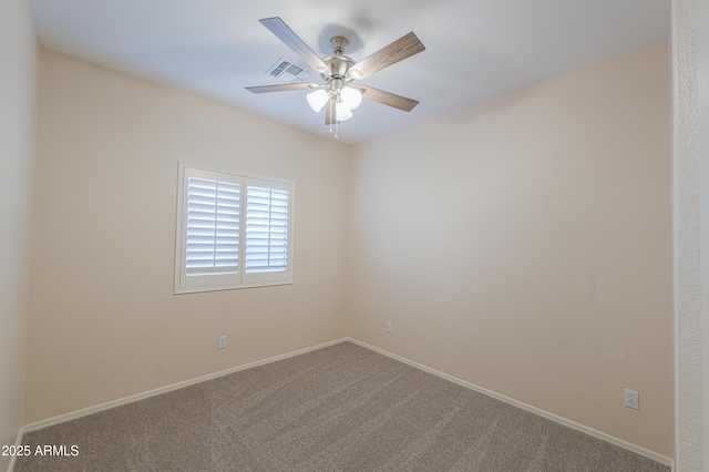 spare room with baseboards, carpet floors, visible vents, and a ceiling fan